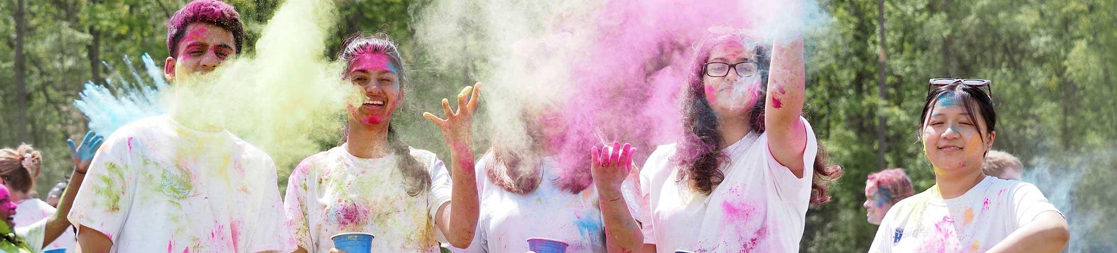 Students throwing up color at holi fest.